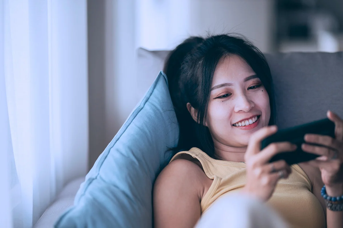 woman watching video on a smartphone on her sofa